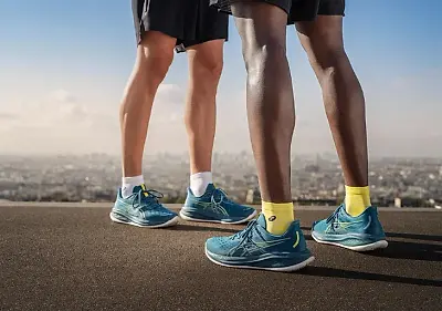 Close up shot of two people wearing a pair of white asics Gel-Cumulus running shoes