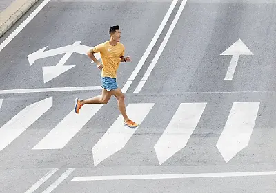 Man running on the street in a pair of hoka verdes Clifton 9 running shoes