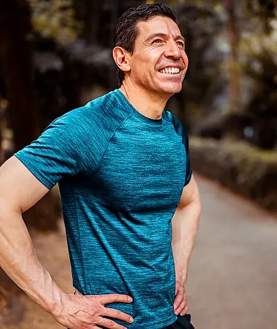 Close up of man in teal athletic shirt as he smiles