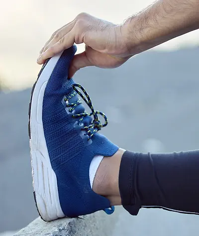 Close up of shoe with cushioned sole on a wall as person pulls back toe box and stretches