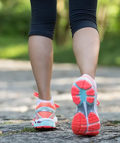 Close up of woman's calves and shoes from behind as she takes a step
